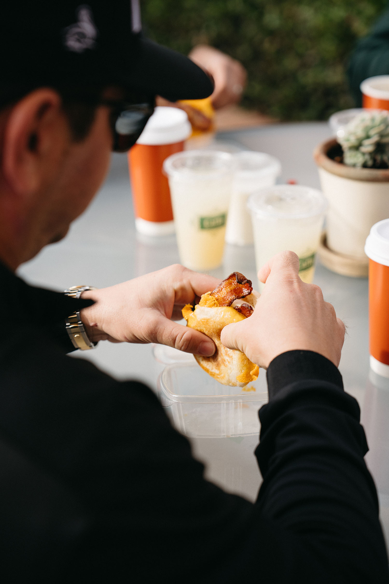 man eating breakfast sandwich at cafe 2